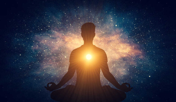 Man and soul. Yoga lotus pose meditation on nebula galaxy background