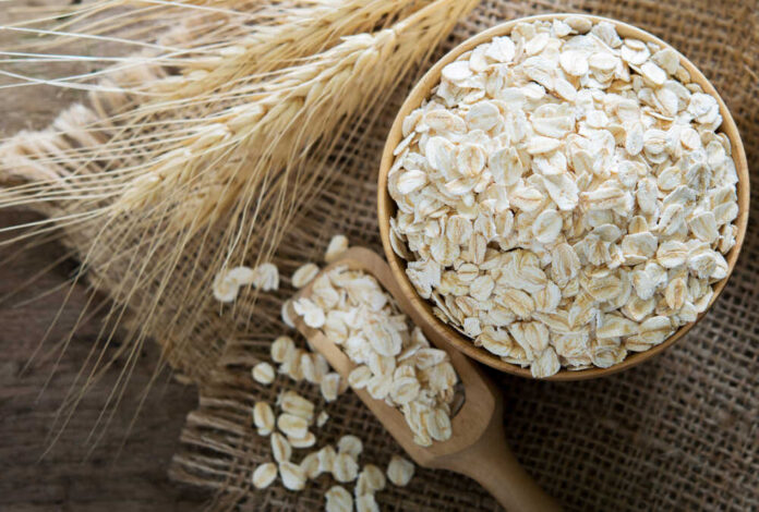 Oat in wooden spoon and bowl.